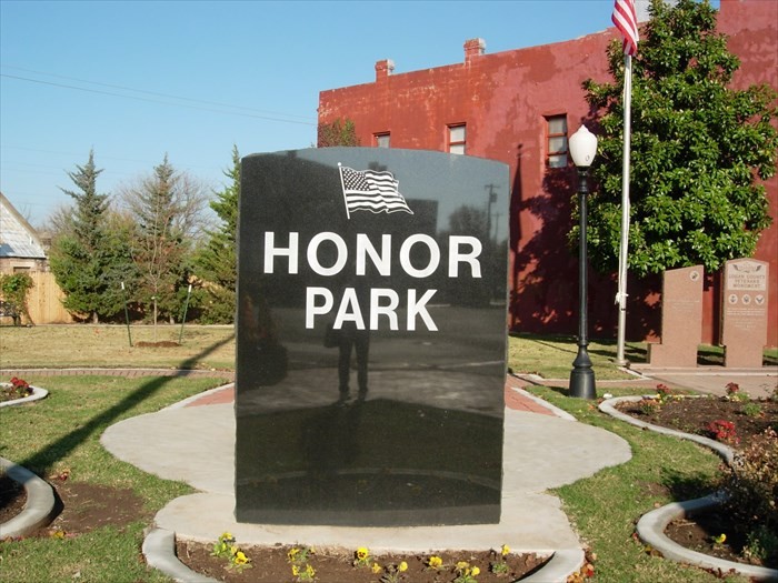 Black granite Honor Park monument in downtown Guthrie with the surrounding memorial park and flagpole